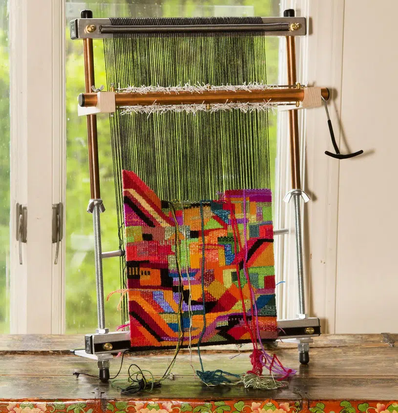 Mirrix weefgetouw met kleurrijk geometrisch tapijtwerk in uitvoering
